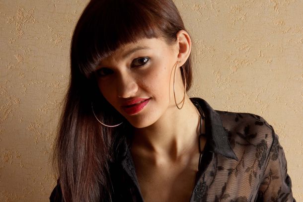 frontal picture of nikki appearing topless wearing a chain around her neck